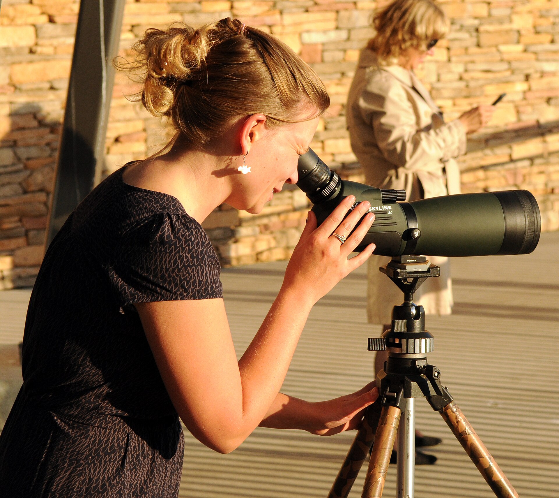 Birder looking through a spotting scope mounted on a tripod